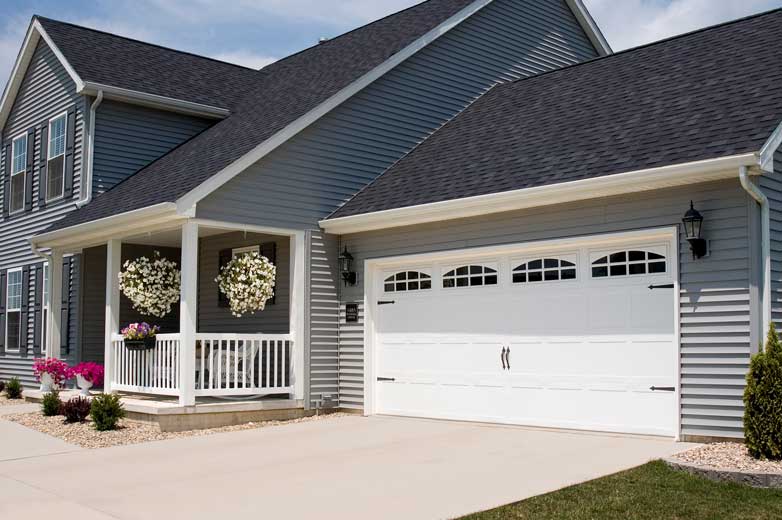 This is an image of a white garage door with arched windows.