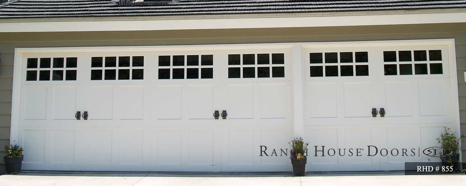 This is an image of a wood cape cod style garage door in white with square windows and handles.