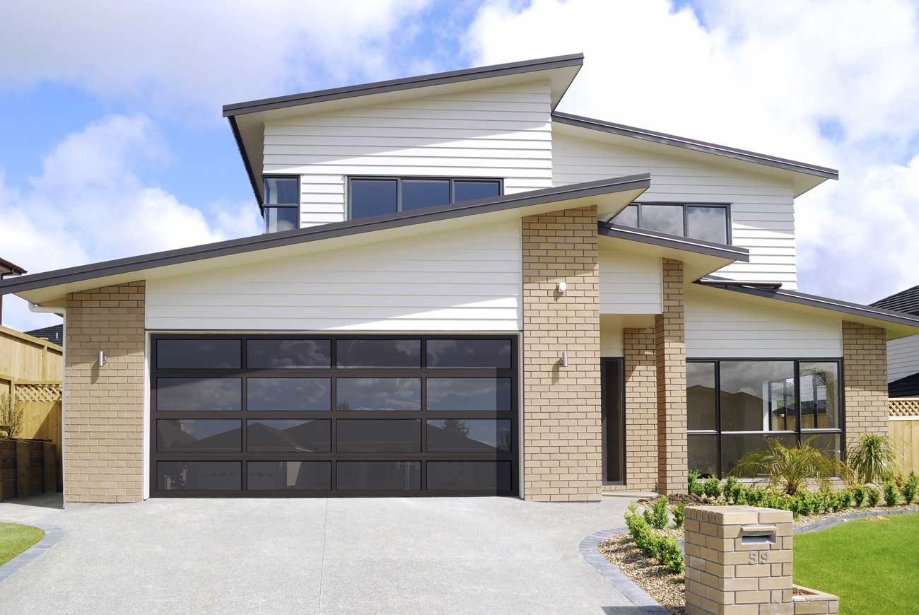 This is an image of an all glass black garage door on a modern home with matches the windows.