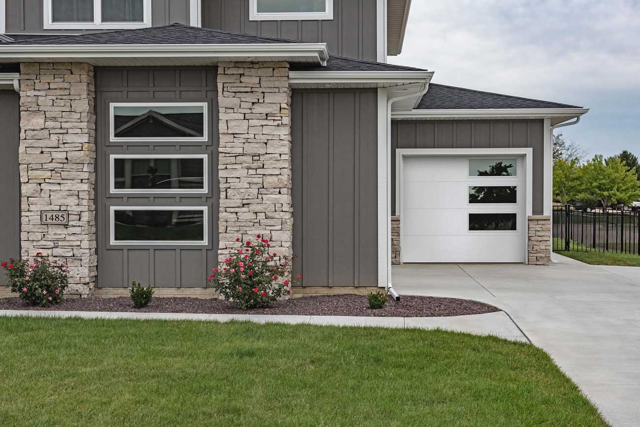 This is an image of a steel modern flush white garage door with glass.