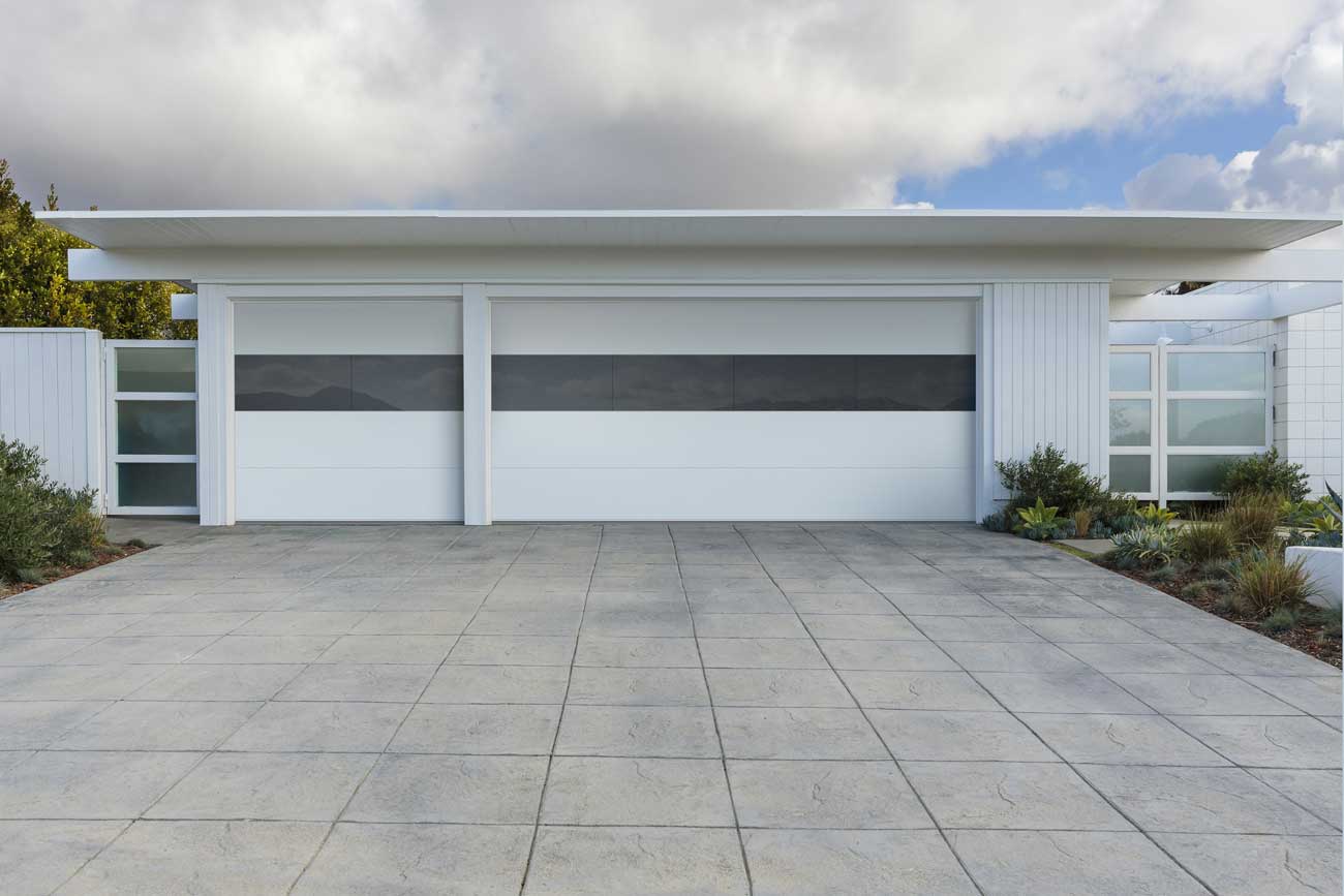 This is an image of a white modern garage door with glass in the middle and flush panels.