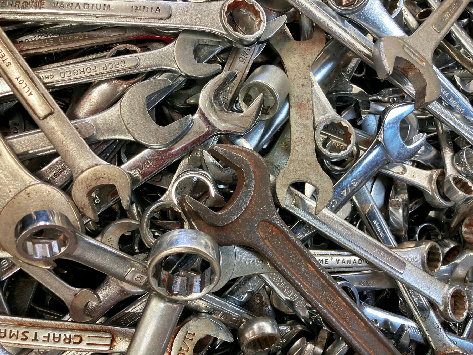 Image of assortment of hand tools used for garage door repair, mostly wrenches.