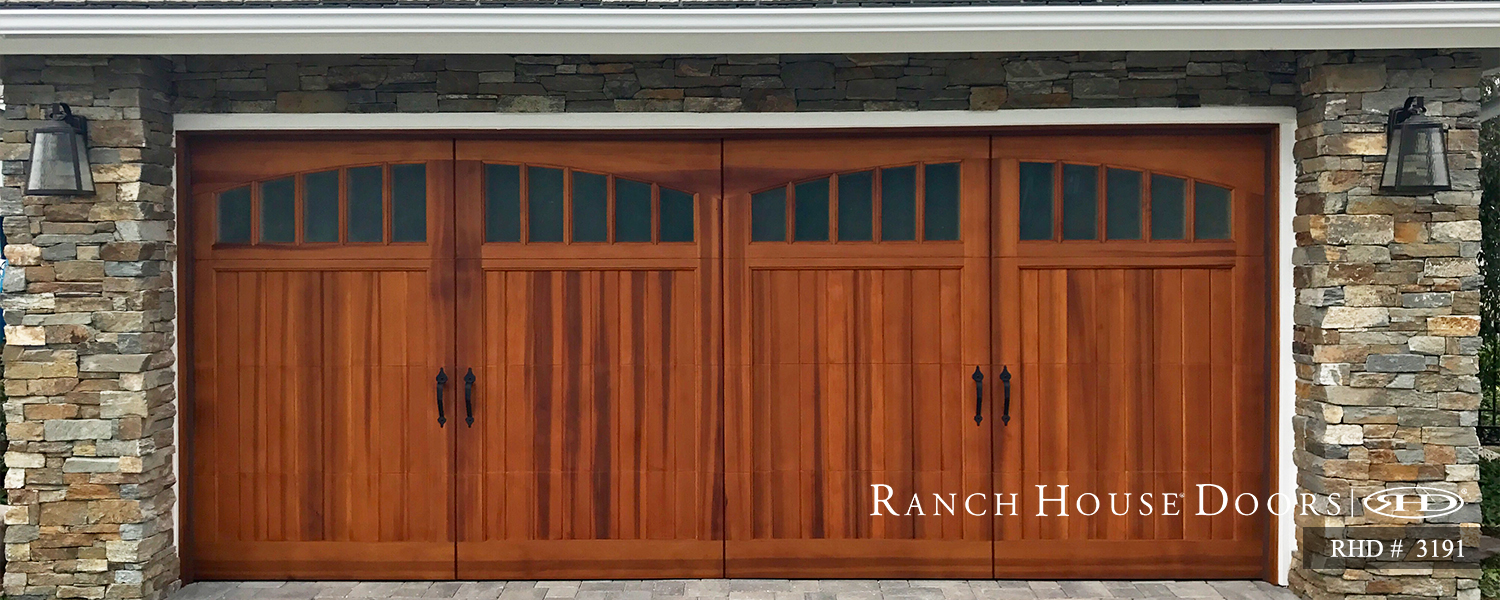 This is an image of a spanish style wood garage door with windows and ornamental hardware in Laguna Niguel, CA.