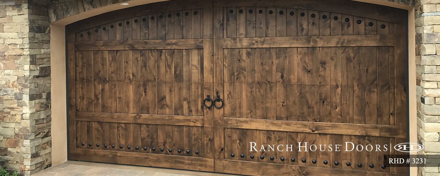 This is an image of a spanish style wood garage door with handles in San Clemente, CA.