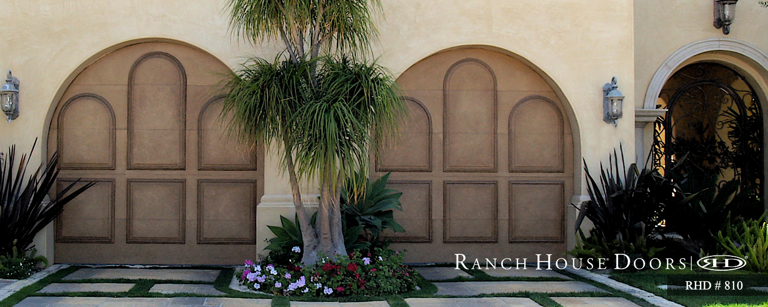 This is an image of a spanish style wood garage door with an arched opening in Newport Coast, CA.