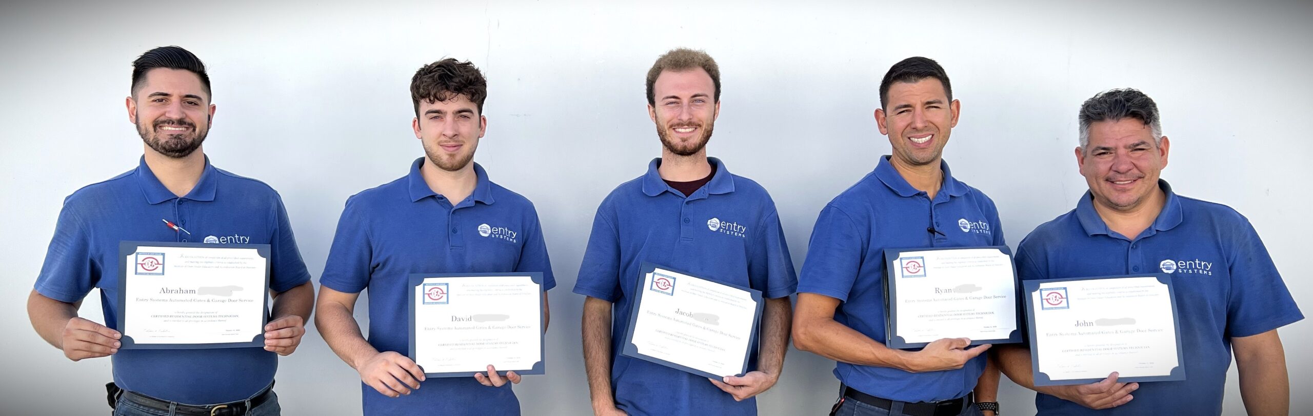 This is a picture of five of our garage door technicians holding up their certificates that they passed accreditation tests.