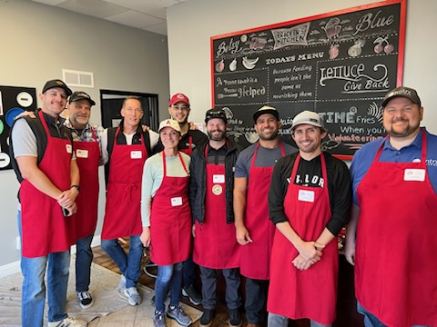 Group of Volunteers at Bracken's Kitchen in Orange County, CA wearing aprons while doing meal prep.