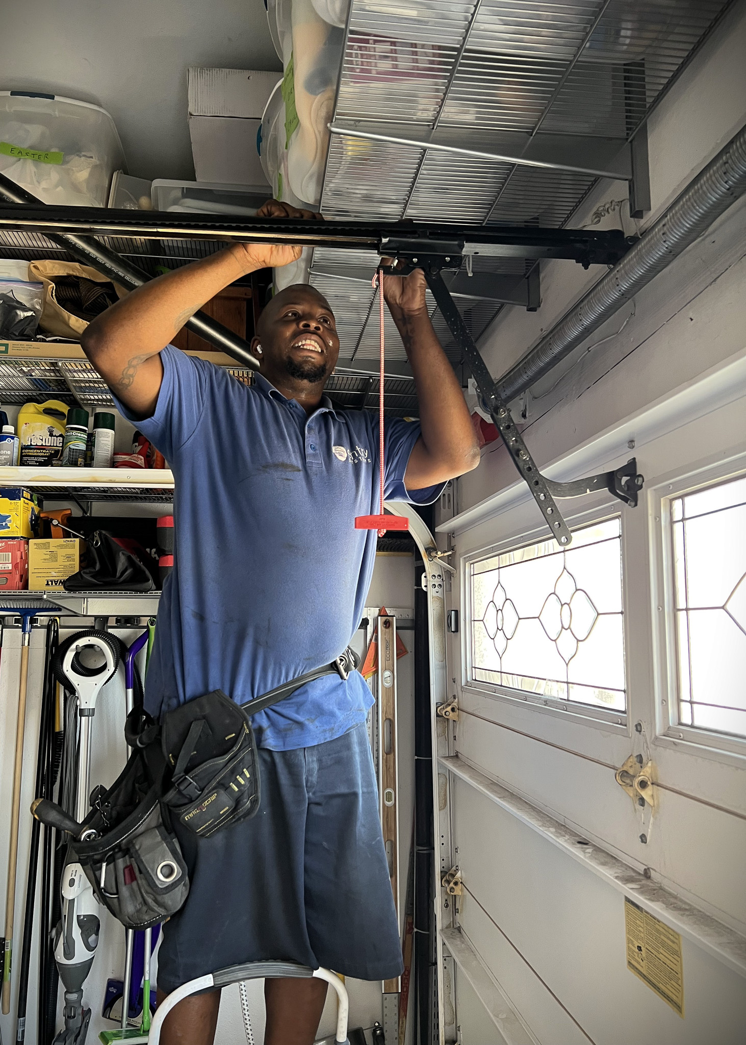 Image of garage door repair technician fixing the trolley on the rail of a garage door opener.
